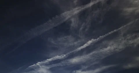 Wispy cirrus and cirrostratus clouds with spreading contrails in a lazy sky. Stock Footage 302789696