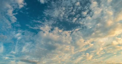 Wispy cirrus and cumulus clouds in sunset sky time lapse Video stock 340772255