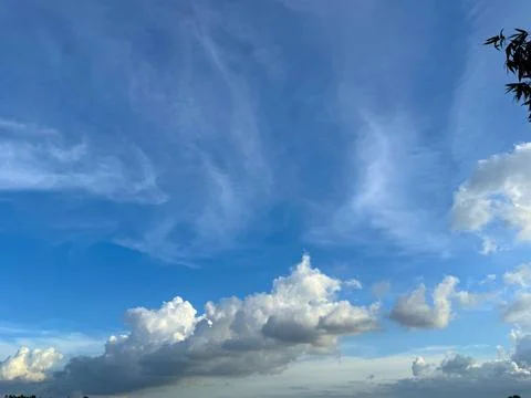 Wispy cirrus clouds create delicate patterns across the expansive blue sky du Stockfoto's