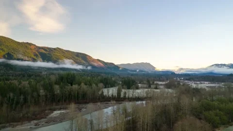 Wispy clouds slowly drift through a mountain river valley, aerial hyper Stock Footage 170398376