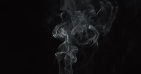 Wispy clouds of smoke over center of dark background Stock Photos