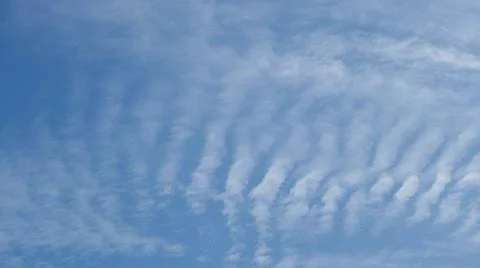 Wispy clouds stretch across a bright blue sky, creating a serene and pictur.. Stock Photos