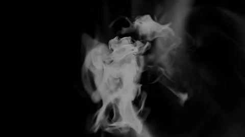 Wispy smoke flowing towards the screen, seamless loop, black background Stock Footage