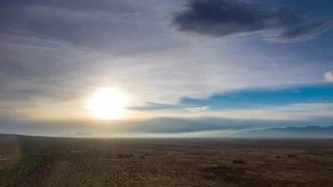Wispy veil of clouds cross the desert as the bright sun heats up the arid Vídeos de archivo 149085474