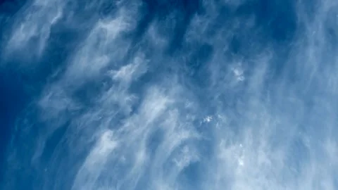 Wispy White Cirrus Clouds Drifting Across a Deep Blue Sky Stock Footage 343824916