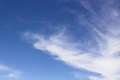 Wispy white clouds in a blue sky. Stock Photos