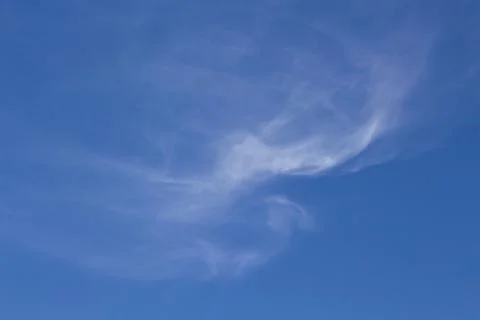 Wispy white clouds in a blue sky. Stock Photos