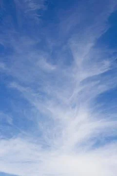 Wispy white clouds in a blue sky. Stock Photos