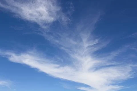 Wispy white clouds in a blue sky. Stock Photos