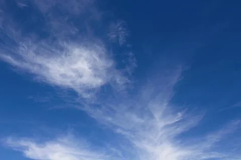 Wispy white clouds in a blue sky. Stock Photos