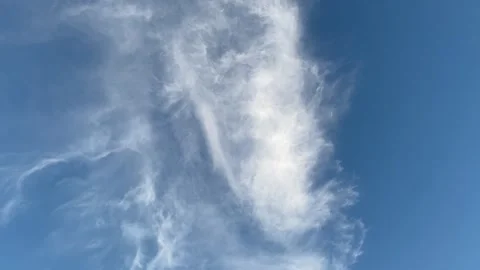 Wispy White Clouds Drifting Across a Clear Blue Sky Stock Footage 336806624