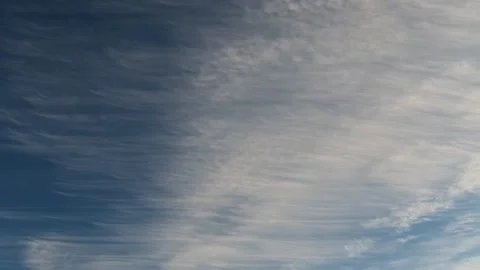 Wispy white clouds moving through a blue sky. Stock Footage 149996454
