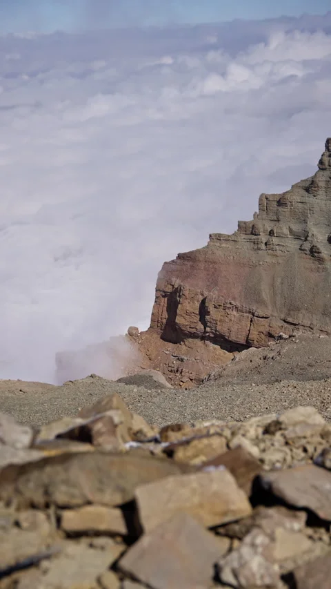 Wispy white clouds passing over jagged mountain ridge, unveiling dramatic Stock Footage 297613435
