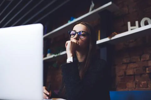 Wistful female touching lips while thinking Stock Photos