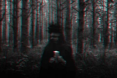 Witch in a black costume performs dark spells with candles in the forest Stockfoto's