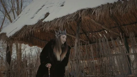 A witch with a black crown on his head and a staff in his hands slowly goes limp Stock Footage 136101806