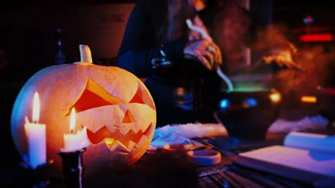 A witch brews a magic potion in a Halloween pot. Stock Footage 285218048
