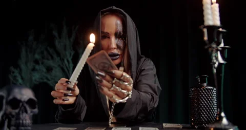 Witch casting spell with dagger over tarot spread Stock Footage 319601605