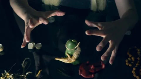 The witch casts a spell leading her hands over magical attributes Stock Footage 134629856