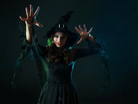 A witch creates magic, a young beautiful brunette in a pointed hat Stock Photos