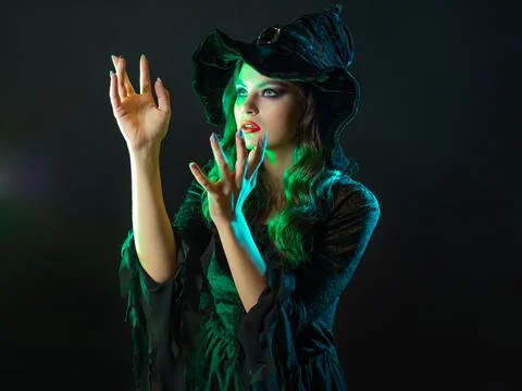 A witch creates magic, a young beautiful brunette in a pointed hat Foto stock