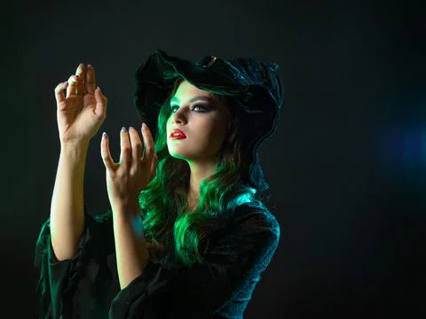 A witch creates magic, a young beautiful brunette in a pointed hat Stock-Fotos