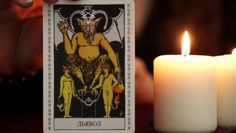 A witch is fortune teller in black mantle show tarot card on dark background. Stock Footage 108013579