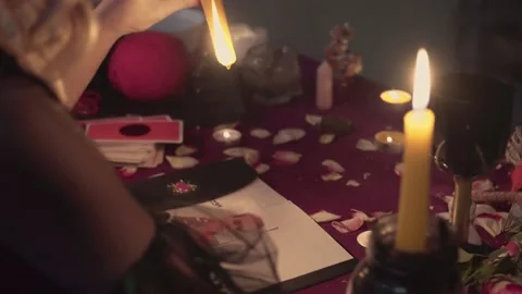Witch fortune teller psychic dripping paraffin on photo of lost person Stock Footage 143508859