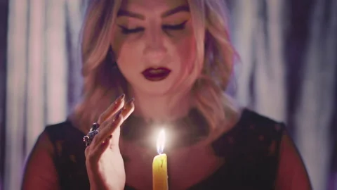 Witch fortune teller psychic hold hand near the candle, casts a spell and Stock Footage 179222568