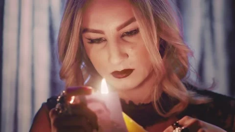 Witch fortune teller psychic moves candle near photo with lost person, and then Stock Footage 143509600