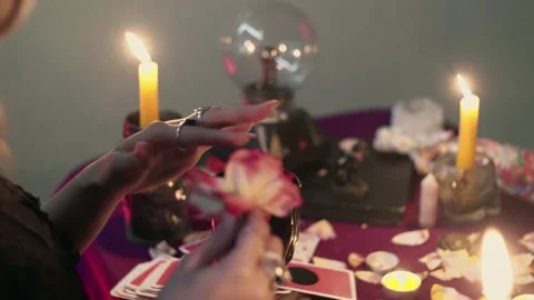 Witch fortune teller psychic picks the petals from a rose, throws them into Stock Footage 143510043