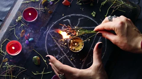 Witch hands burning herbs for a black magic ritual with magical altar Stock Footage 243094290