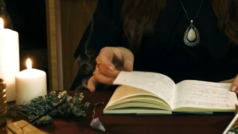 Witch hold hands over book, read spell and call spirits. Divination concept. Stock Footage 108023658