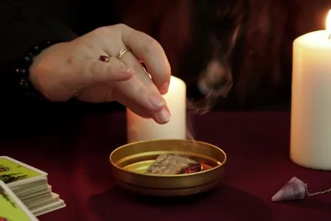 A witch holding hand over steaming paper. Occult, esoteric and wicca concept. Stock Photos