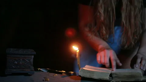 Witch holding the magic ritual. old book and candle. halloween Stock Footage 64670324
