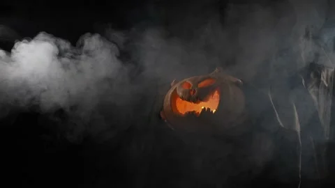 The witch is holding a pumpkin jack o lantern glowing in the dark. Halloween. Stock Footage 164047156