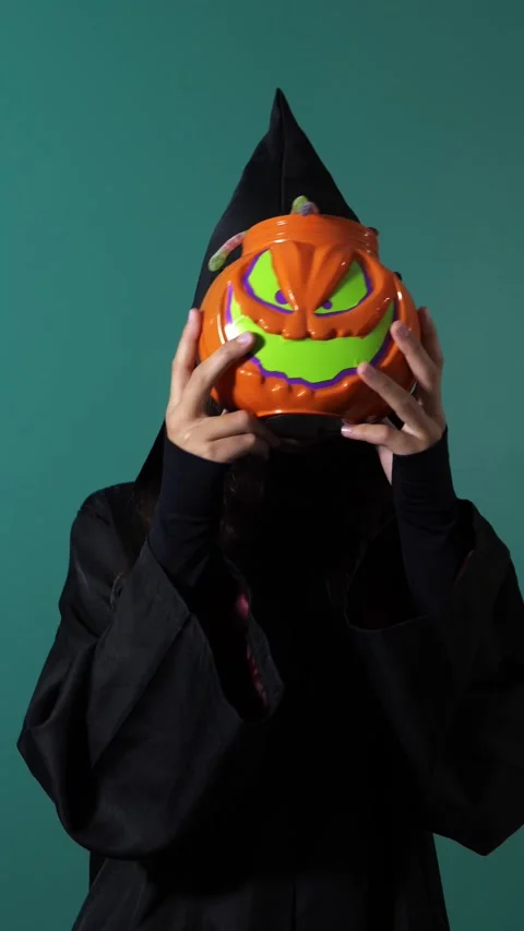 Witch holding spooky jack-o-lantern pumpkin pail for Halloween Stock Footage 342521554