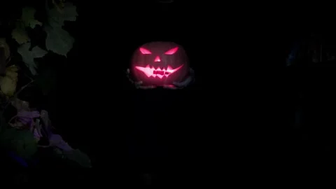 Witch holds a scary pumpkin in her hands, a girl looks at a scary pumpkin Stock Footage 251820482