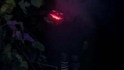 Witch holds a scary pumpkin in her hands, a girl looks at a scary pumpkin Stock Footage 251820521