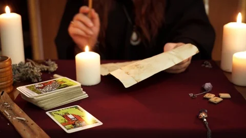 A witch ignite candle, read spell and drip wax on the paper. Occult concept. Video stock 108013442