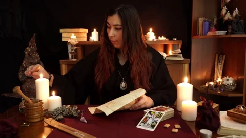 Witch ignite esoteric candle, read spell and drip wax on paper with spell. Stock Footage 108010437