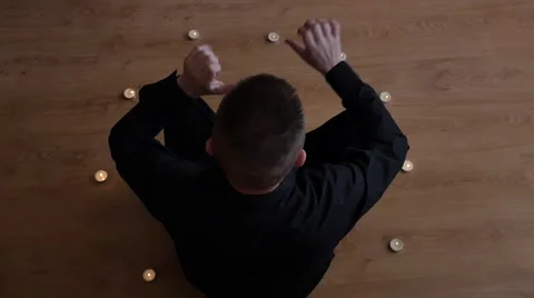 Witch man in candle circle making spiritual ritual - slow motion Stock Footage