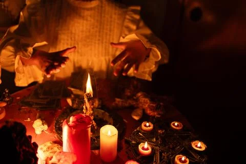Witch performing a dark magic ritual with burning candles, tarot cards and 스톡 사진