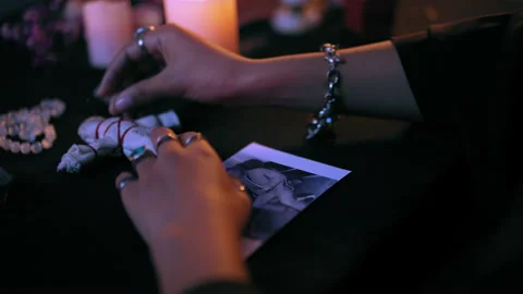 Witch performing occult ritual over man's photo, pushing needles in voodoo doll Stock Footage 179972827