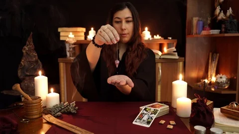Witch performs a rite of black magic. Pendulum say Yes. Magical ritual. Stock Footage 108010292