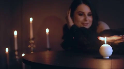 A witch performs a rite or a love spell in a dark room with burning candles Stock Footage 242426306