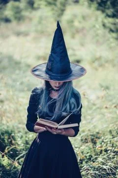 Witch reading a book of magic Stock Photos