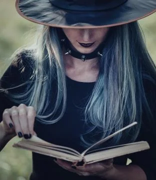 Witch reading a book of magic Stock Photos