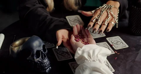 Witch reading client palm in mystical fortune ritual with tarot cards Stock Footage 320007413