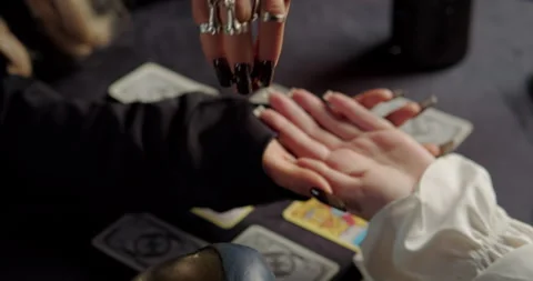 Witch reading client palm in mystical fortune ritual Stock Footage 320008718